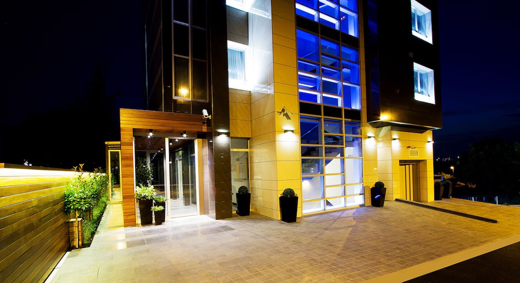 Hotel Heritage u Beogradu noću, moderno osvetljena zgrada sa elegantnim ulazom i staklenim fasadama